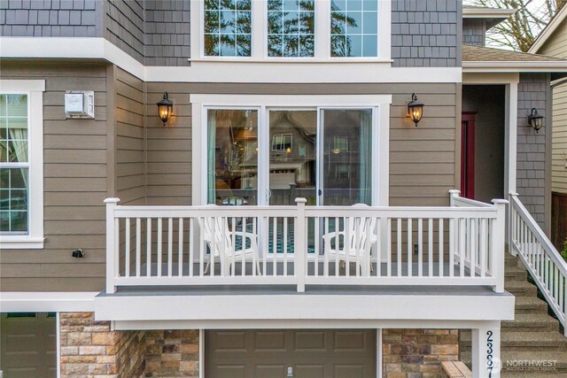 property entrance featuring stone siding and roof with shingles