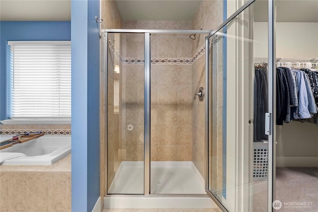 full bathroom with a garden tub, a stall shower, and a spacious closet