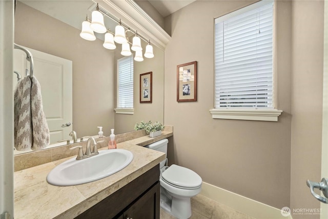 bathroom featuring vanity, toilet, baseboards, and tile patterned flooring