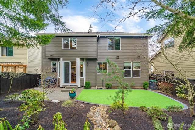 rear view of property with a yard, a patio, and fence