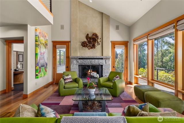 living room with high vaulted ceiling, a wealth of natural light, and wood-type flooring