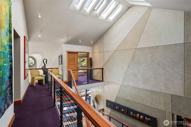 hallway with vaulted ceiling with skylight