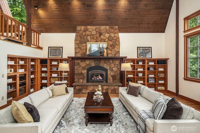 living room featuring hardwood / wood-style flooring, a stone fireplace, wooden ceiling, and high vaulted ceiling