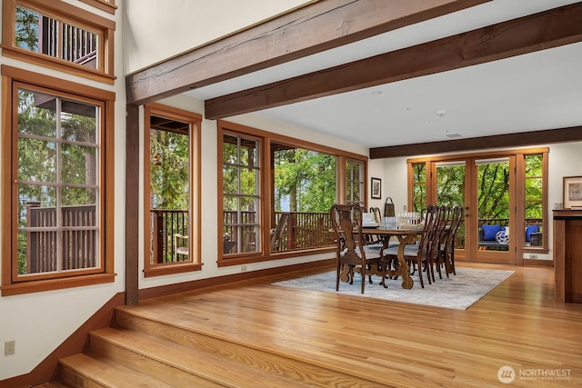 dining space featuring french doors, beam ceiling, and light hardwood / wood-style floors