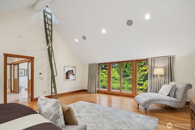 bedroom featuring beam ceiling, light hardwood / wood-style flooring, and high vaulted ceiling