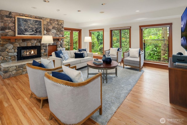 living room with plenty of natural light, a fireplace, and light wood-type flooring