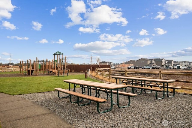 view of home's community featuring fence, a lawn, and playground community