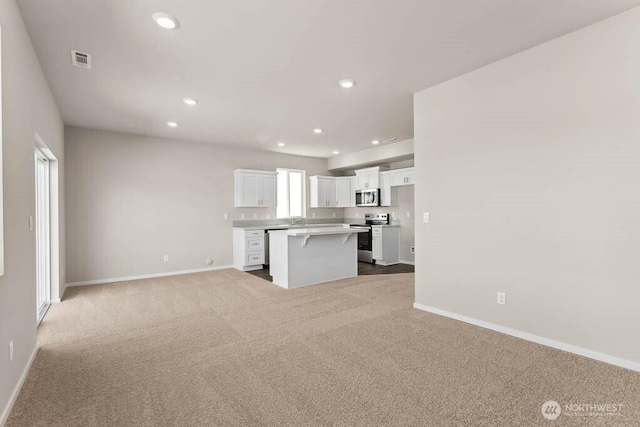 kitchen featuring visible vents, open floor plan, recessed lighting, stainless steel appliances, and white cabinets