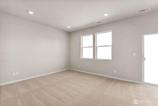 unfurnished room with light carpet, visible vents, recessed lighting, and baseboards