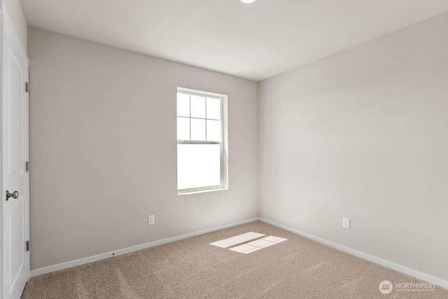 carpeted spare room with baseboards