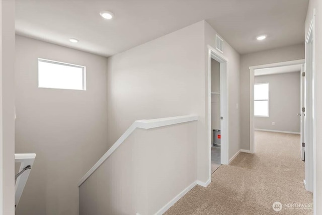 hall with visible vents, baseboards, recessed lighting, carpet flooring, and an upstairs landing