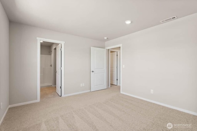 unfurnished bedroom featuring baseboards, visible vents, and light carpet