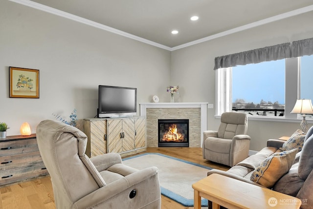 living room with ornamental molding, light wood-type flooring, a fireplace, and recessed lighting