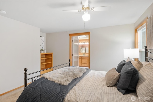 bedroom with connected bathroom, light carpet, a ceiling fan, baseboards, and baseboard heating