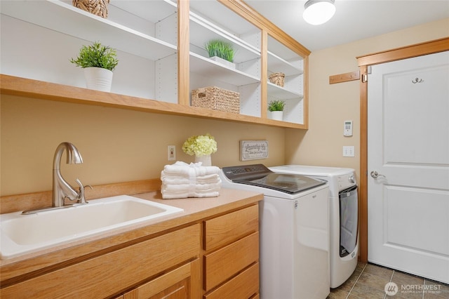 laundry room featuring cabinet space, light tile patterned floors, a sink, and independent washer and dryer