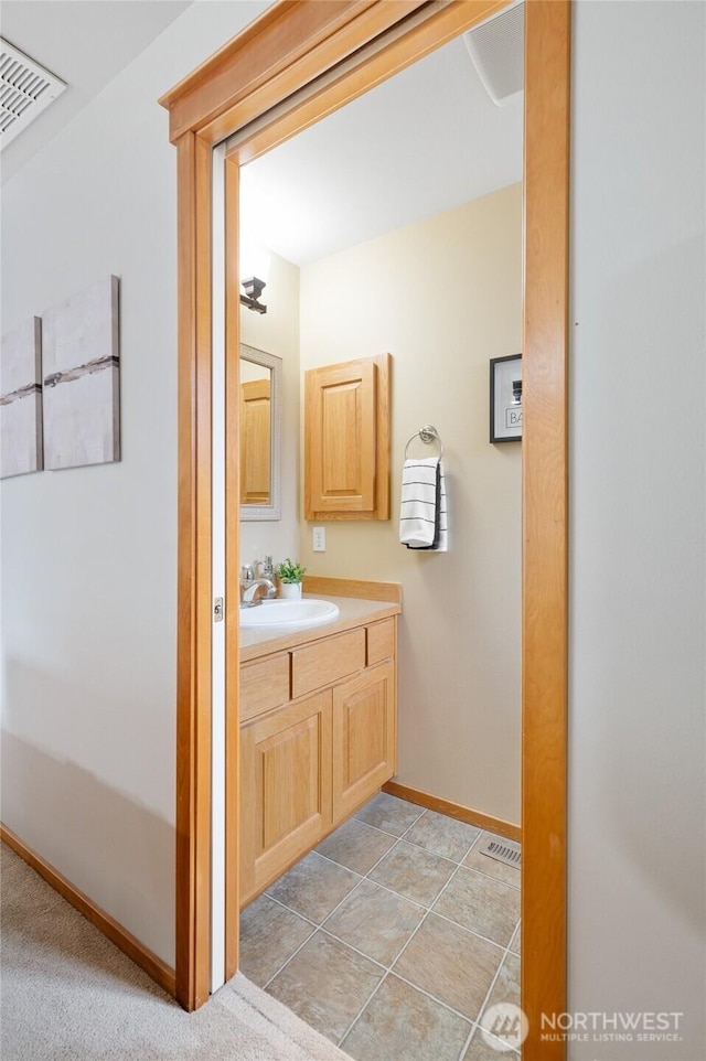 bathroom featuring tile patterned floors, baseboards, visible vents, and vanity