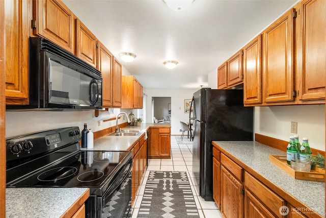 kitchen featuring light tile patterned floors, sink, and black appliances