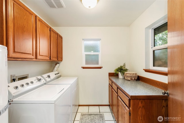 washroom with cabinets, a healthy amount of sunlight, separate washer and dryer, and light tile patterned floors