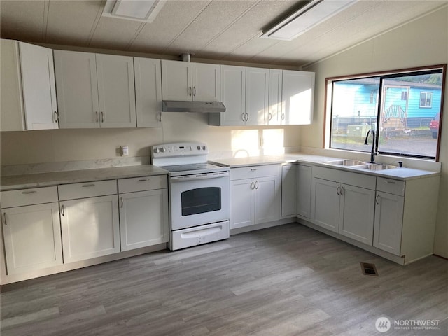 kitchen with vaulted ceiling, white electric stove, white cabinetry, sink, and light hardwood / wood-style floors