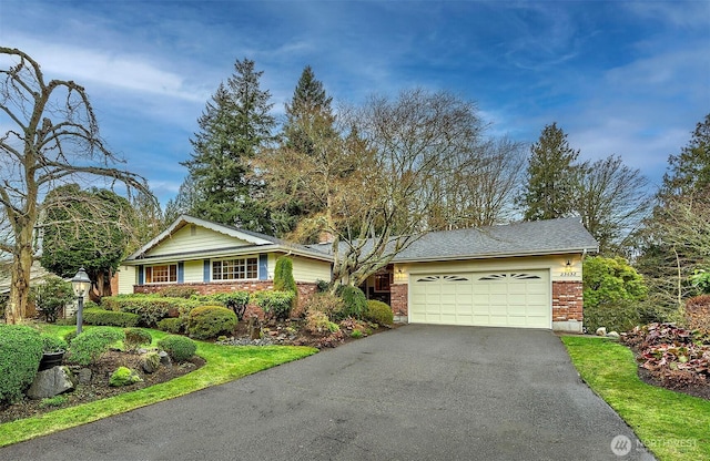 ranch-style house with a garage, driveway, and brick siding