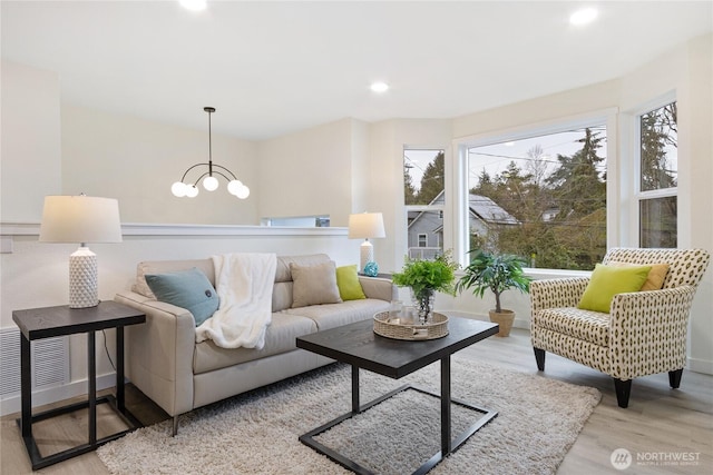 living room with a notable chandelier, visible vents, wood finished floors, and recessed lighting