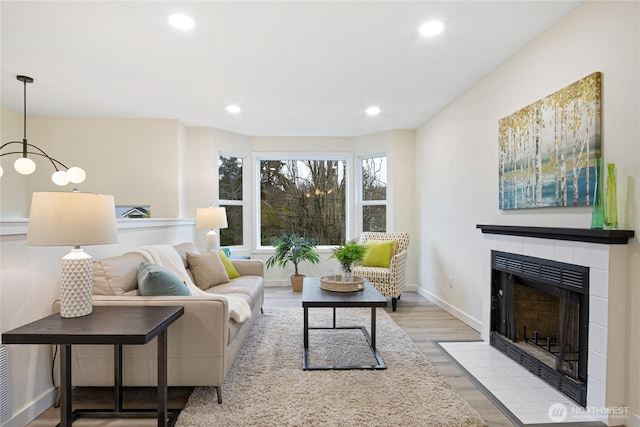 living area with light wood-style floors, recessed lighting, a fireplace, and baseboards