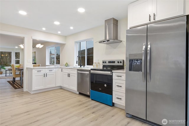 kitchen featuring white cabinets, wall chimney range hood, stainless steel appliances, and light countertops