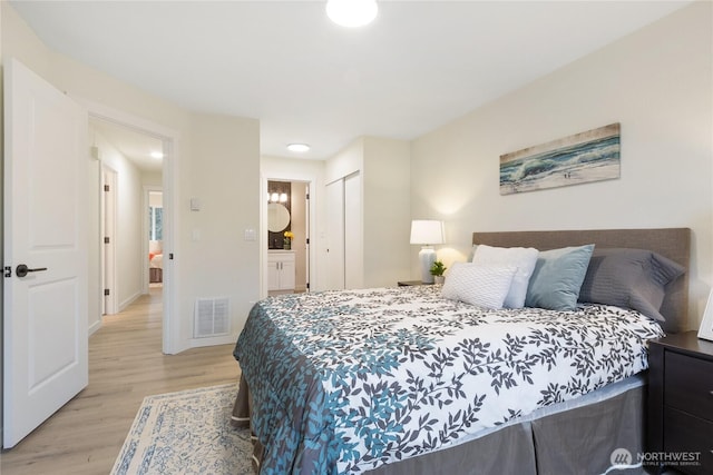 bedroom with light wood finished floors, a closet, visible vents, and baseboards