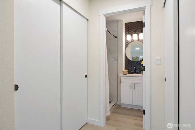 full bath featuring a shower, wood finished floors, and vanity