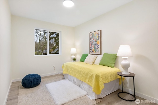 bedroom featuring baseboards and wood finished floors