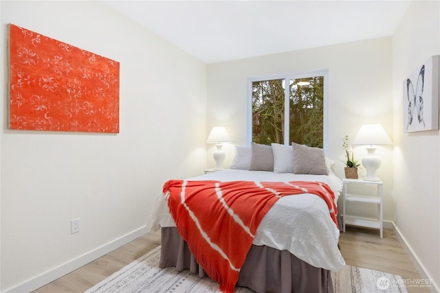 bedroom featuring baseboards and wood finished floors