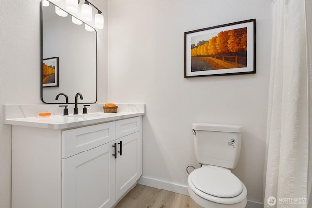 full bathroom featuring vanity, wood finished floors, toilet, and baseboards