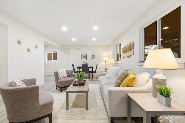 living room featuring light wood-style flooring, baseboards, and recessed lighting