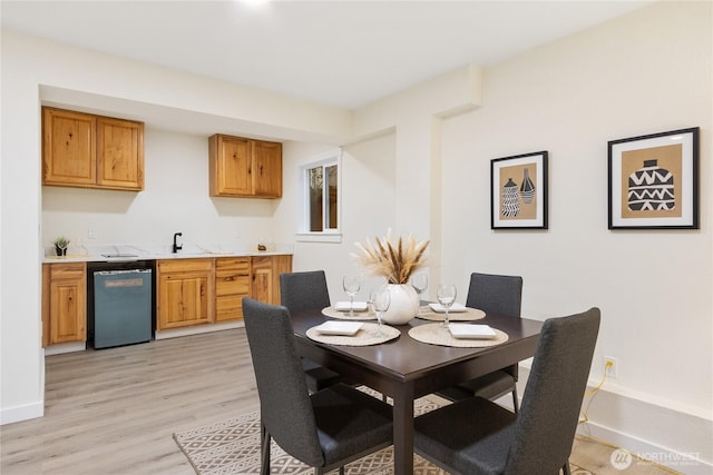 dining area featuring light wood-style flooring and baseboards