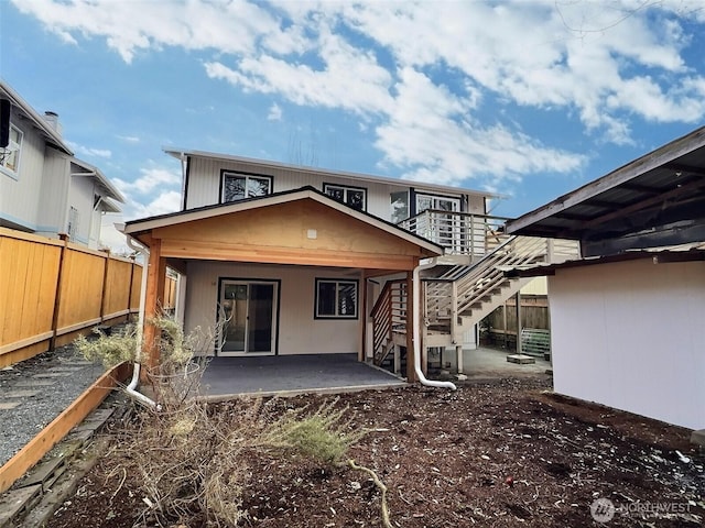 back of house featuring stairway, a patio area, and fence