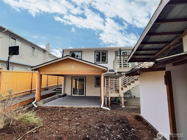 rear view of property with a patio, stairway, and fence