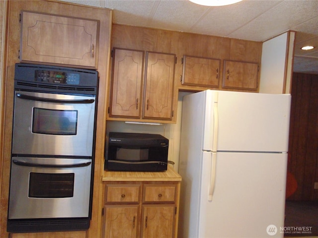 kitchen featuring white fridge and stainless steel double oven