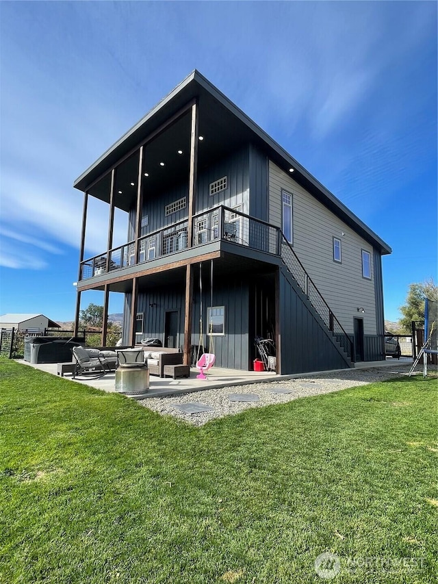 rear view of property with a lawn, stairs, a patio area, an outdoor living space, and board and batten siding