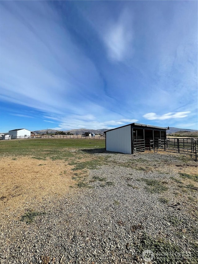 exterior space featuring an exterior structure, a rural view, and an outdoor structure