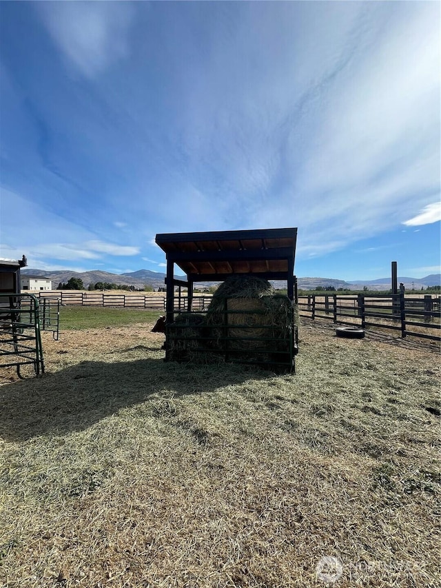 view of outdoor structure featuring a mountain view, an outbuilding, and a rural view