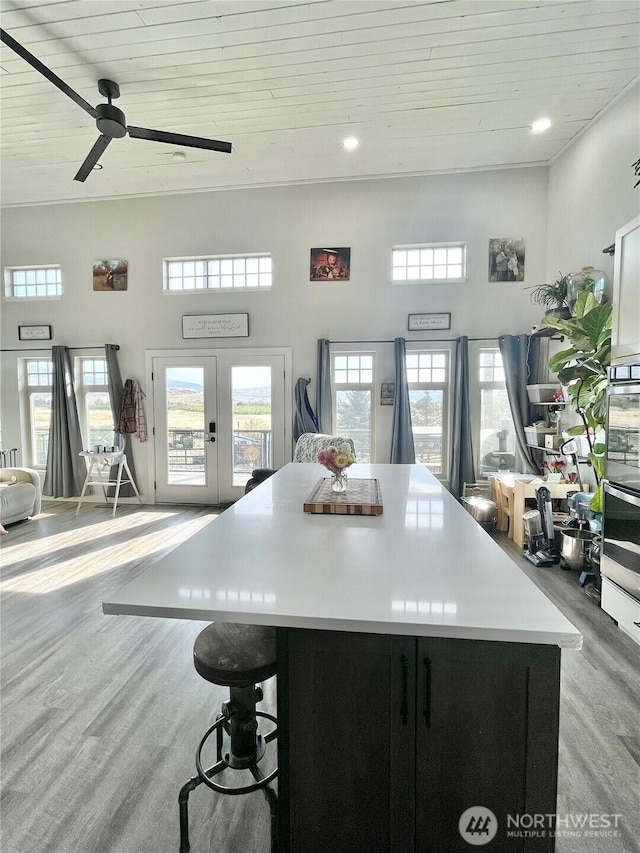 kitchen featuring light wood-style floors, wood ceiling, a wealth of natural light, and a center island