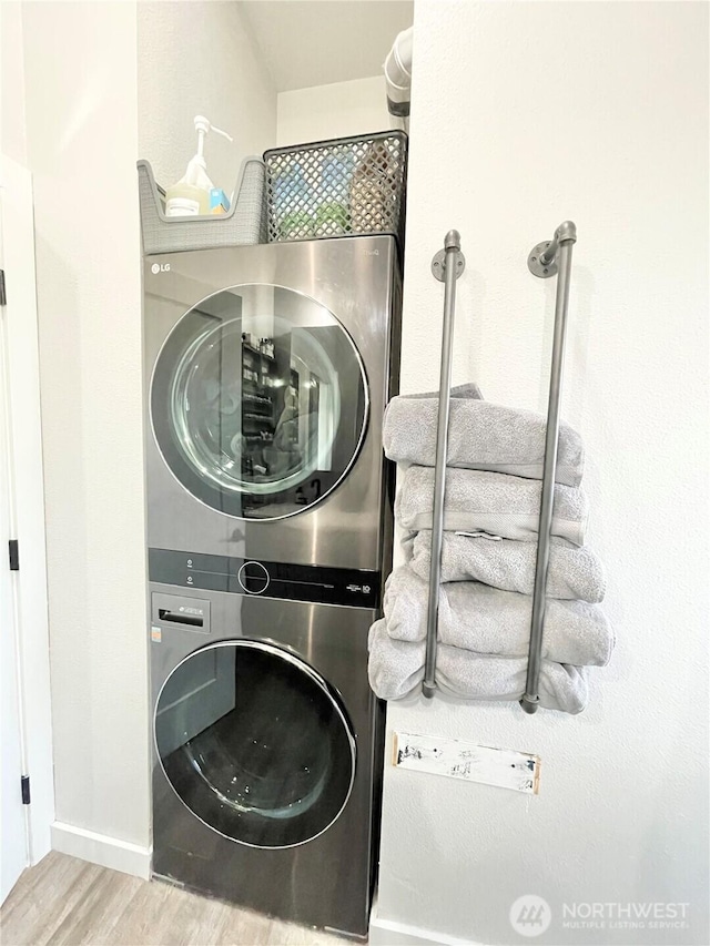 washroom featuring stacked washer / dryer and wood finished floors