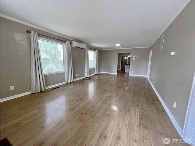 unfurnished living room with wood-type flooring, ornamental molding, and an AC wall unit