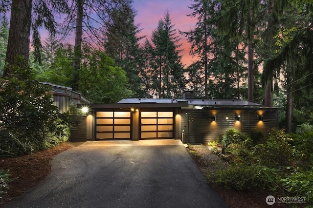 modern home with an attached garage and aphalt driveway