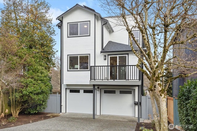 front facade with a garage and a balcony