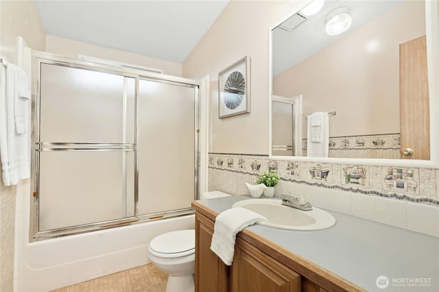 full bath with toilet, enclosed tub / shower combo, and vanity