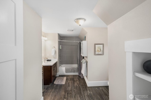 bathroom with shower / bath combination, wood finished floors, vanity, and baseboards