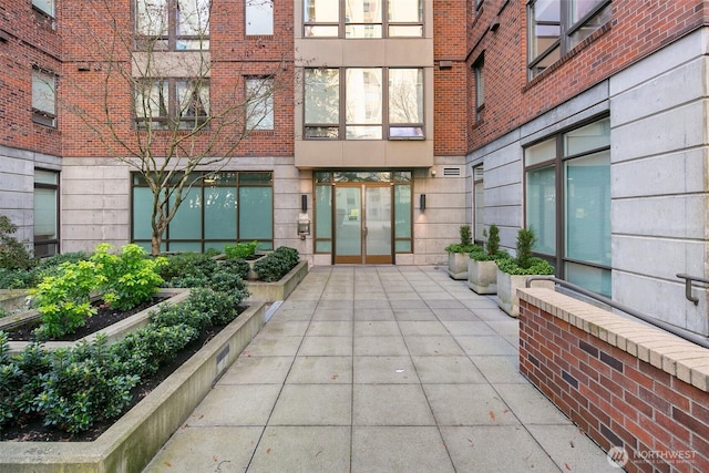 doorway to property featuring brick siding