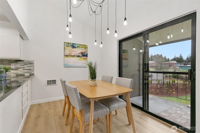 dining room with light wood-type flooring, baseboards, and visible vents