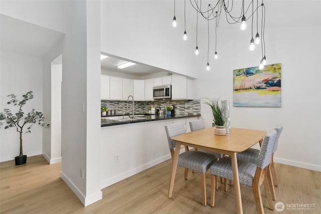 dining space featuring light wood-type flooring and baseboards